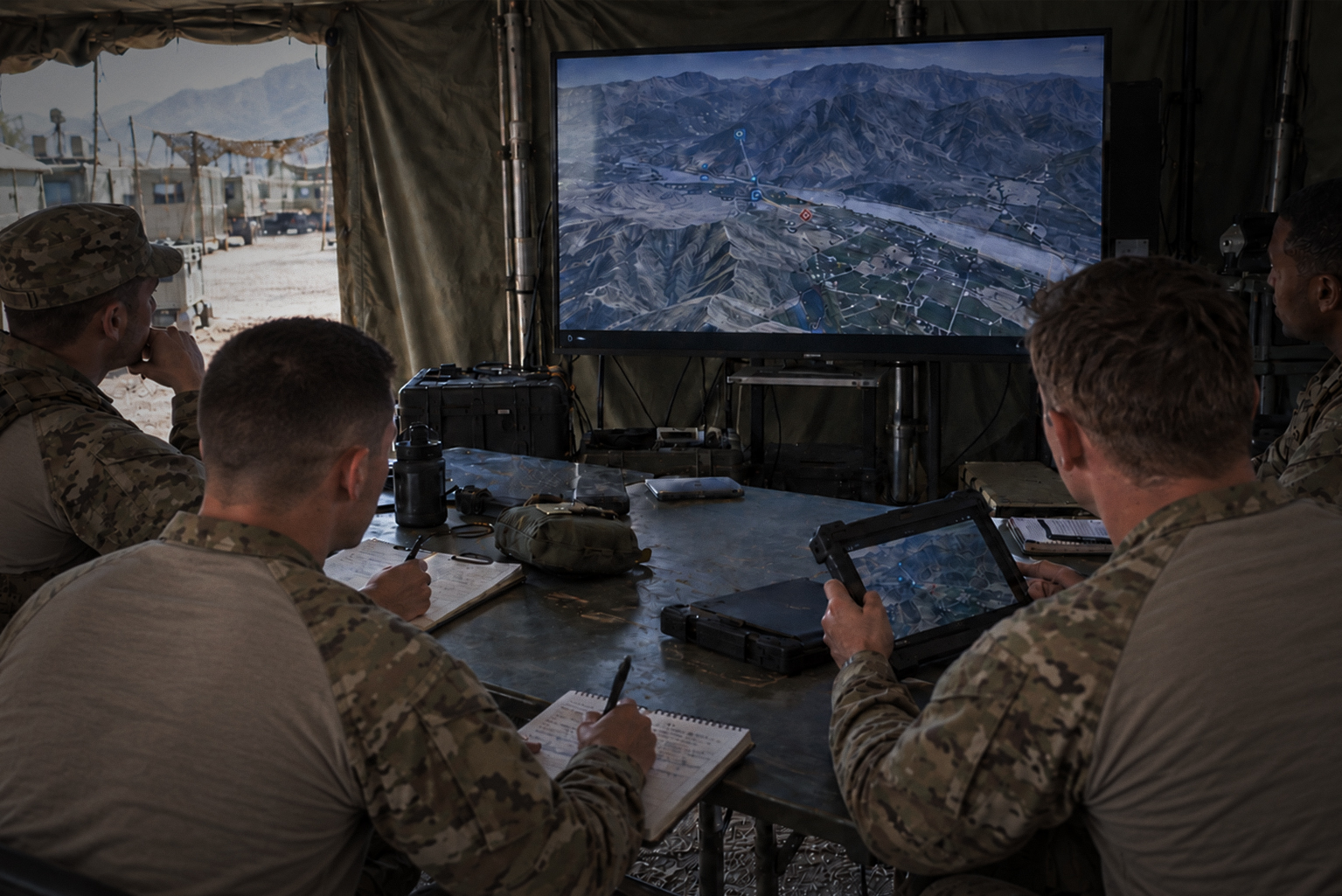 Exercise control team monitoring training from a command tent